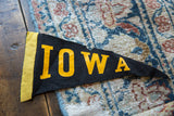 Yellow felt edge with part of the black 'I' on a vintage Iowa pennant.