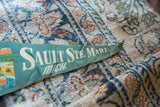Off-white serif lettering on the textured green felt of a vintage Michigan pennant.