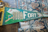 Yellow hoist and detailed graphic of the Fort Wilkins site on a vintage teal pennant.