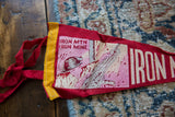 Yellow stitched border and faded graphic detail on a vintage red felt Iron Mountain pennant.