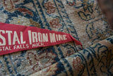 Red felt pennant detail displaying white 'Iron Mine' text and felt texture.