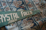 Vintage green felt Crystal Falls Michigan flag with imperfect beige lettering.