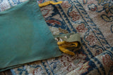 Detail of the vintage felt banner's green texture with folded yellow accent.