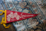 Red felt Vintage Louisiana Flag with white magnolia graphic and yellow ties.