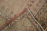 Hand-knotted reverse and intact pale rose selvage on a vintage distressed Oushak rug.