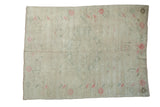 Vintage distressed Oushak rug with a subtle diamond medallion in soft ivory, pink, and pale green tones.