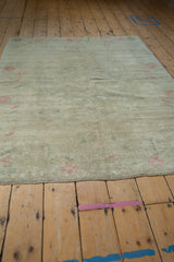 Low angle view across the distressed, low-pile surface of a vintage Turkish Oushak rug.