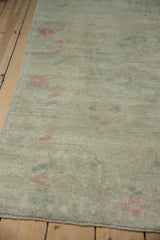 Angled view of a distressed Oushak's low pile, highlighting the even wear to the knot heads.