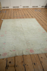 The soft, time-worn texture and muted palette of a vintage distressed Turkish Oushak rug.