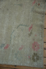 Distressed Oushak rug pile showing even wear to the knot heads and pale floral border motifs.