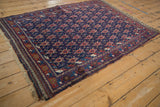 Antique Persian Afshar rug from an angle, highlighting the allover turtle-style pattern.