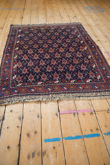 Angled view of an antique Afshar rug showing its rhythmic, staggered turtle design elements.