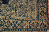 Antique Senneh rug detail: intricate Herati field, geometric border, aged pile, and tattered selvage.