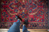 Vintage Lilihan Persian rug's cherry red field with navy blue floral border.