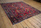 Vintage Persian Lilihan rug corner: navy blue floral border, cherry red field, intact selvage.