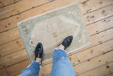 Distressed vintage Oushak rug pile shows even wear in cream and seafoam green.