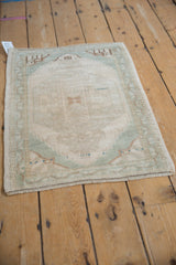 Distressed texture and cream, seafoam green corner motif on the vintage Turkish Oushak rug.