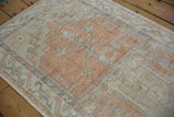 Distressed texture of a vintage Oushak runner's geometric floral design in pale tangerine and slate.