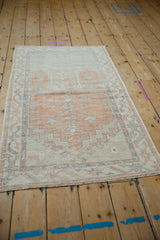 Perspective view of a distressed Turkish Oushak runner in soft tangerine and slate.