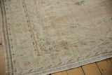 Distressed texture of vintage Oushak rug showing faded ivory, dusty sage, and weaver lines.