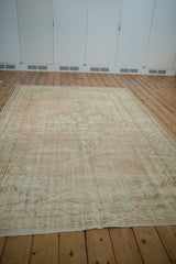 Distressed pile and abrash on the vintage Oushak rug in ivory, sage, and blush.
