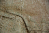 Faded patterns and distressed pile texture of a vintage Oushak carpet.