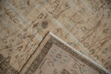 Distressed vintage Oushak rug pile with mostly even wear, folded to show its striped foundation and selvage.
