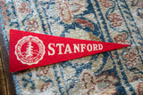Red felt Stanford University pennant with white school name and crest detail.