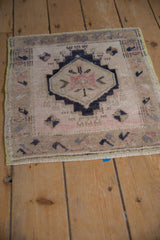Distressed Oushak rug detail: stepped center medallion with pale blush, dark navy fills.