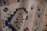 Softened pile texture with geometric motifs in beige, navy, and blush on a vintage Oushak rug.