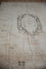 Soft, lustrous pile on a distressed Oushak rug with faded ivory and muted gray patterns.