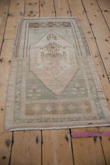Distressed vintage Oushak rug border featuring pale ivory and faded geometric patterns.