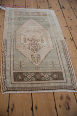 Distressed vintage Turkish Oushak rug with faded Ladik style niches in soft green and ivory.