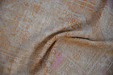 Textured pile of a distressed vintage Oushak rug with pale tangerine and fuchsia.