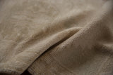 Textural close-up of a vintage distressed Oushak rug with muted beige and ivory pile.