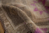 Distressed Kars rug pile with visible knot heads and fuchsia geometric design.