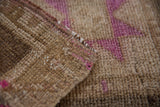 Distressed Kars rug pile with fuchsia, ivory, and silver tones, showing intact side selvage.