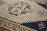 Distressed pile texture of vintage Oushak rug, showing navy geometric border and ivory field.