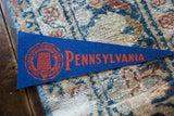 Royal blue vintage Pennsylvania University felt pennant with red crest and 'PENNSYLVANIA' text.