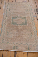 Distressed Oushak runner, showing even wear across muted ivory and seafoam green patterns.