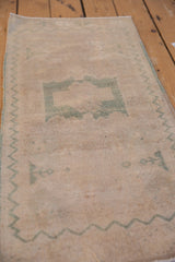 Distressed Oushak rug pile texture with dusty seafoam green zigzag border.
