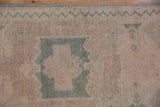 Vintage Distressed Oushak rug texture with worn pile and faded seafoam green geometric patterns.