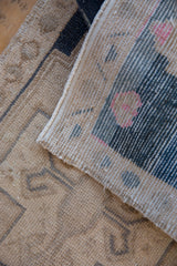 Detail of the vintage Oushak rug's hand-knotted reverse, revealing its weave and painted number.