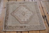 Corner detail of distressed Oushak rug, showing stepped pattern, intact selvage, and even wear.