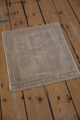 The distressed square Oushak rug showing its low, textured pile and neutral colorway.