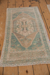 Soft pale green turquoise and sand tones on the distressed Oushak rug's floral motifs.