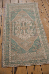 Vintage Distressed Oushak runner upper corner with pale green turquoise spandrel and soft beige pile.