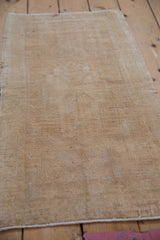 Distressed Oushak rug detail, highlighting even wear, sand beige texture, and selvage.