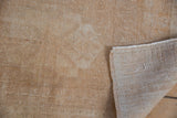 Hand-knotted Oushak rug with tightly woven foundation and distressed antique ivory pile.