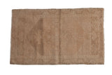 Distressed Oushak rug mat with faded beige abrashed field and subtle serrated medallion.